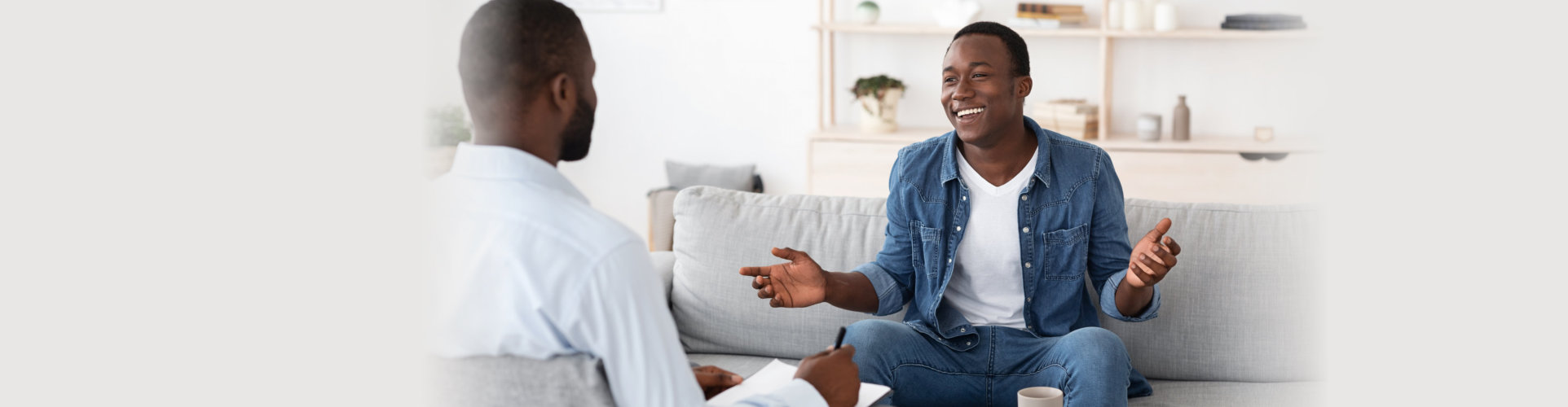 Cheerful man talking to psychologist on meeting at his office